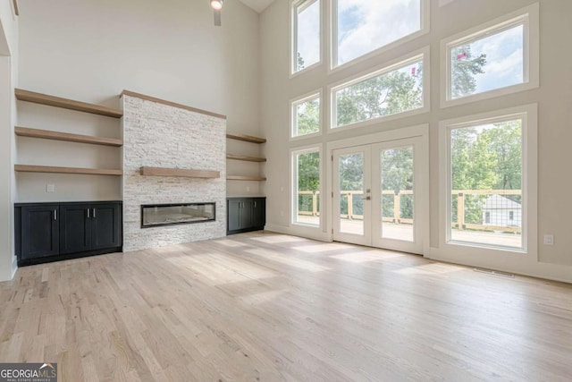 2555 Chattahoochee Ln, Cumming, GA 30041 - unfurnished living room featuring a high ceiling, plenty of natural light, light wood-style floors, and a fireplace