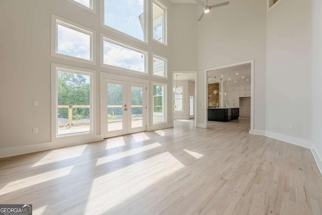 2555 Chattahoochee Ln, Cumming, GA 30041 - unfurnished living room with plenty of natural light, french doors, a high ceiling, and light wood finished floors