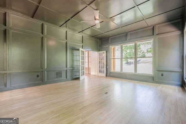 2555 Chattahoochee Ln, Cumming, GA 30041 - empty room featuring a decorative wall, ceiling fan, wood finished floors, french doors, and coffered ceiling