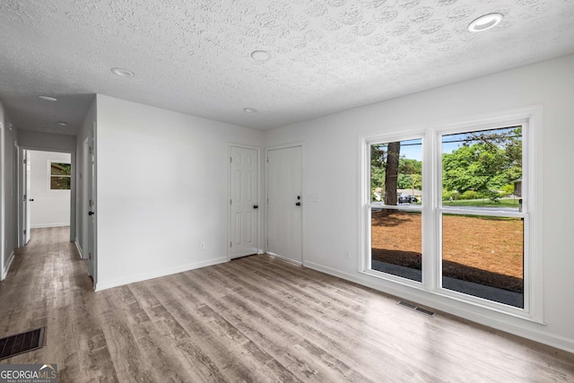 6932 Eunice Dr, Riverdale, GA 30274 - spare room featuring a textured ceiling, wood finished floors, and baseboards