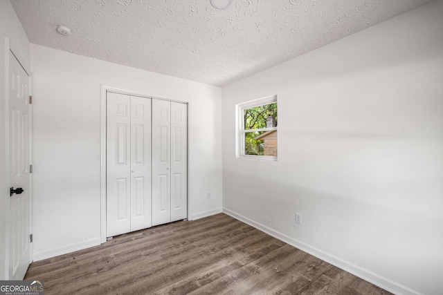 6932 Eunice Dr, Riverdale, GA 30274 - unfurnished bedroom with a textured ceiling, wood finished floors, baseboards, and a closet