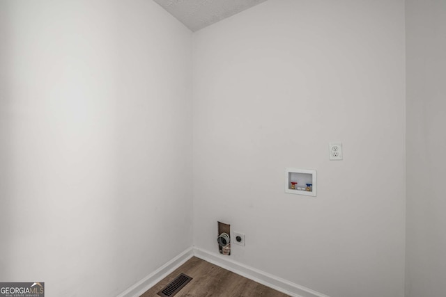 6932 Eunice Dr, Riverdale, GA 30274 - laundry room with hookup for an electric dryer, washer hookup, dark wood-type flooring, baseboards, and a textured ceiling