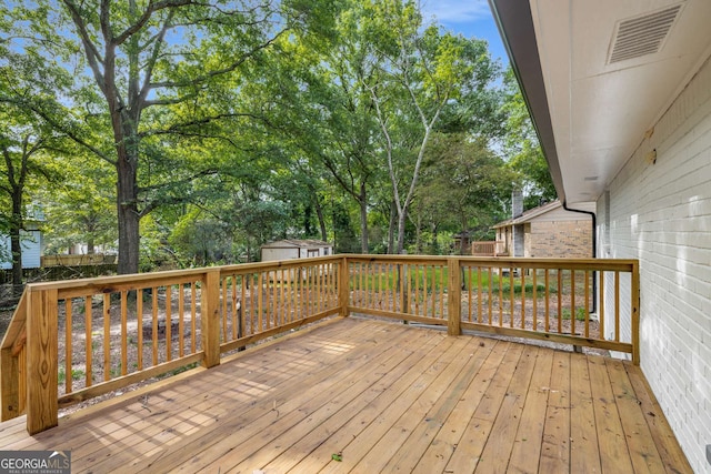 6932 Eunice Dr, Riverdale, GA 30274 - wooden deck with a shed, an outdoor structure, and view of wooded area