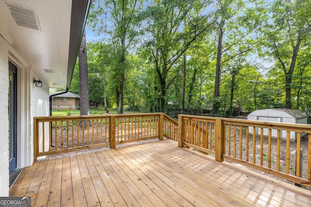 6932 Eunice Dr, Riverdale, GA 30274 - wooden terrace with a storage shed, an outdoor structure, and view of scattered trees