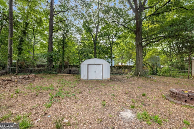6932 Eunice Dr, Riverdale, GA 30274 - fenced backyard with a shed, an outdoor fire pit, and an outdoor structure