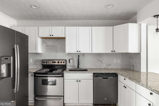 6932 Eunice Dr, Riverdale, GA 30274 - kitchen featuring stainless steel appliances, a sink, a textured ceiling, white cabinetry, and light stone countertops