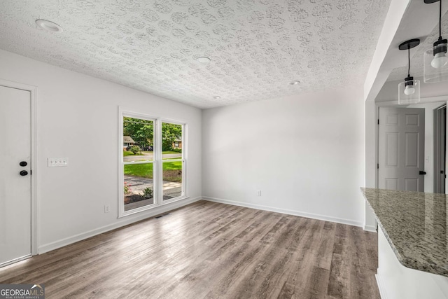 6932 Eunice Dr, Riverdale, GA 30274 - unfurnished living room featuring wood finished floors, baseboards, and a textured ceiling