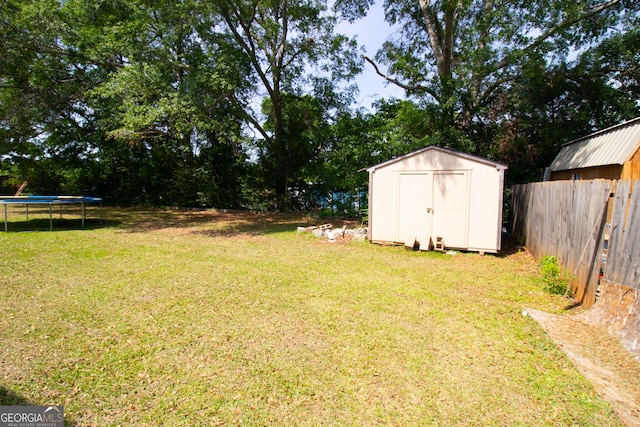 view of yard with a trampoline, a storage shed, and an outdoor structure