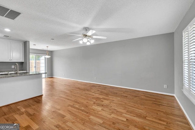 2866 Florence Dr, Gainesville, GA 30504 - unfurnished living room with ceiling fan, light wood-style floors, a sink, a textured ceiling, and baseboards