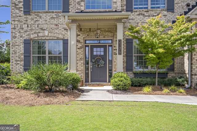 3179 Falls Crest Ct, Buford, GA 30519 - property entrance with a yard, brick siding, and stone siding