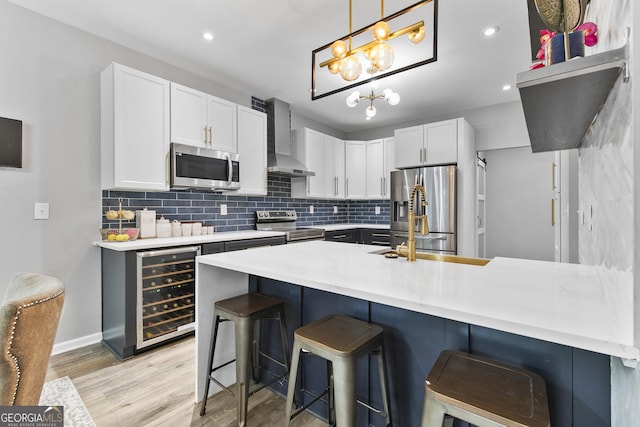 3 Tiffany Trce, Palmetto, GA 30268 - kitchen featuring stainless steel appliances, wall chimney exhaust hood, wine cooler, a peninsula, and a breakfast bar