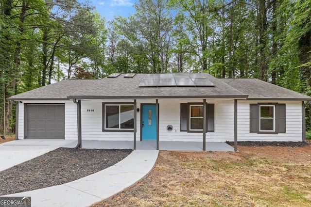 3216 Montheath Ct, Duluth, GA 30096 - single story home with covered porch, an attached garage, a shingled roof, driveway, and solar panels