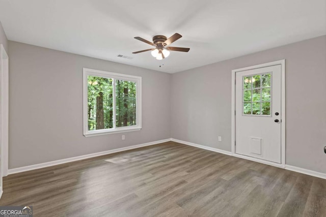 3216 Montheath Ct, Duluth, GA 30096 - spare room featuring plenty of natural light, a ceiling fan, wood finished floors, and baseboards