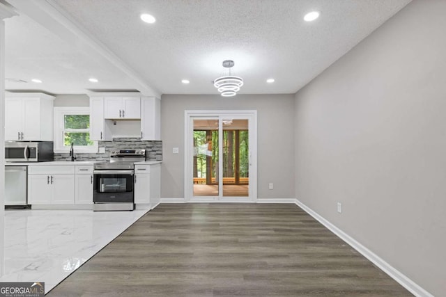 3216 Montheath Ct, Duluth, GA 30096 - kitchen with appliances with stainless steel finishes, white cabinetry, baseboards, backsplash, and recessed lighting