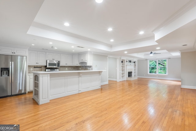 1000 Admiral Xing, Alpharetta, GA 30005 - unfurnished living room featuring a tray ceiling, ceiling fan, light wood-style flooring, recessed lighting, and ornamental molding