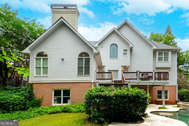 1000 Admiral Xing, Alpharetta, GA 30005 - rear view of house featuring brick siding, a chimney, a wooden deck, and a lawn