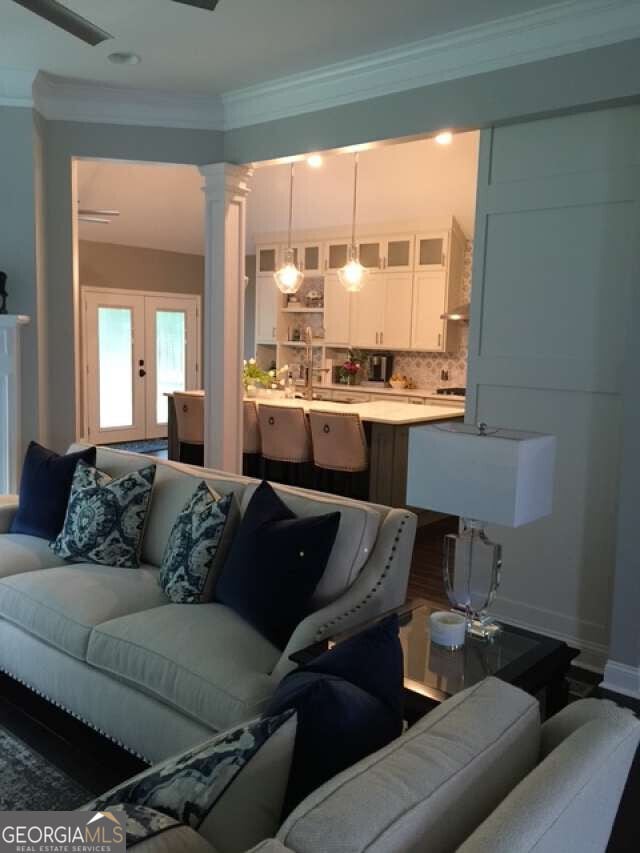 1305 Lake Forest Ln, Mcdonough, GA 30253 - living room with crown molding, decorative columns, french doors, and baseboards