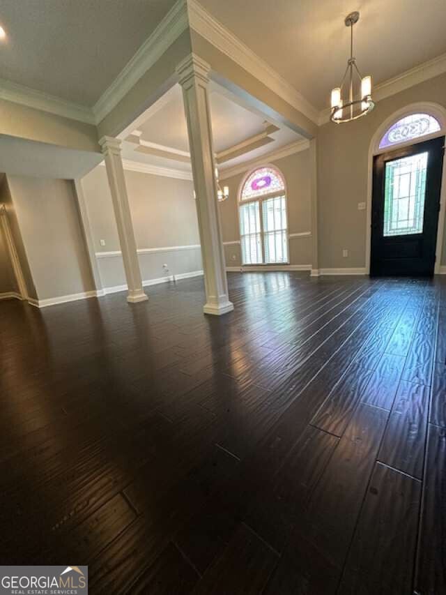 1305 Lake Forest Ln, Mcdonough, GA 30253 - foyer entrance with ornate columns, plenty of natural light, dark wood finished floors, baseboards, and ornamental molding