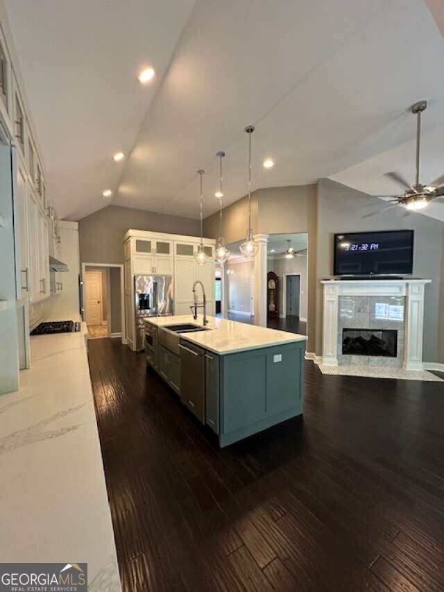 1305 Lake Forest Ln, Mcdonough, GA 30253 - kitchen featuring a ceiling fan, a sink, lofted ceiling, white cabinets, and dark wood finished floors
