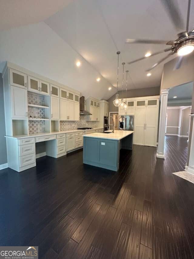 1305 Lake Forest Ln, Mcdonough, GA 30253 - kitchen with wall chimney exhaust hood, lofted ceiling, ceiling fan, white cabinets, and light countertops