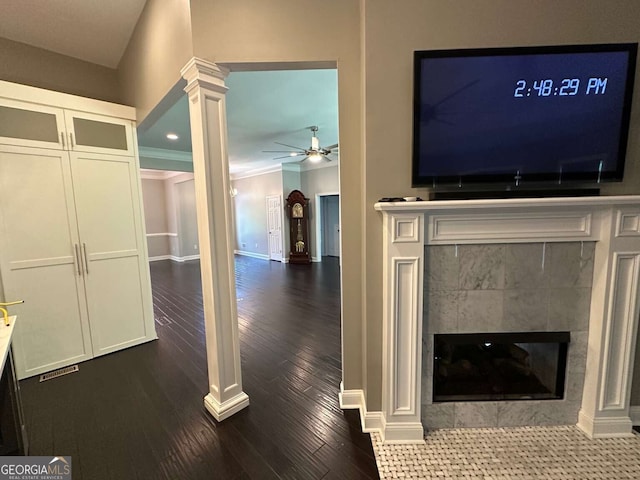 1305 Lake Forest Ln, Mcdonough, GA 30253 - unfurnished living room with dark wood-style floors, a ceiling fan, a tile fireplace, baseboards, and crown molding