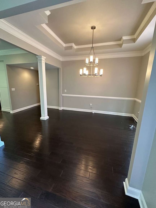 1305 Lake Forest Ln, Mcdonough, GA 30253 - unfurnished dining area with a tray ceiling, hardwood / wood-style flooring, ornamental molding, ornate columns, and a chandelier