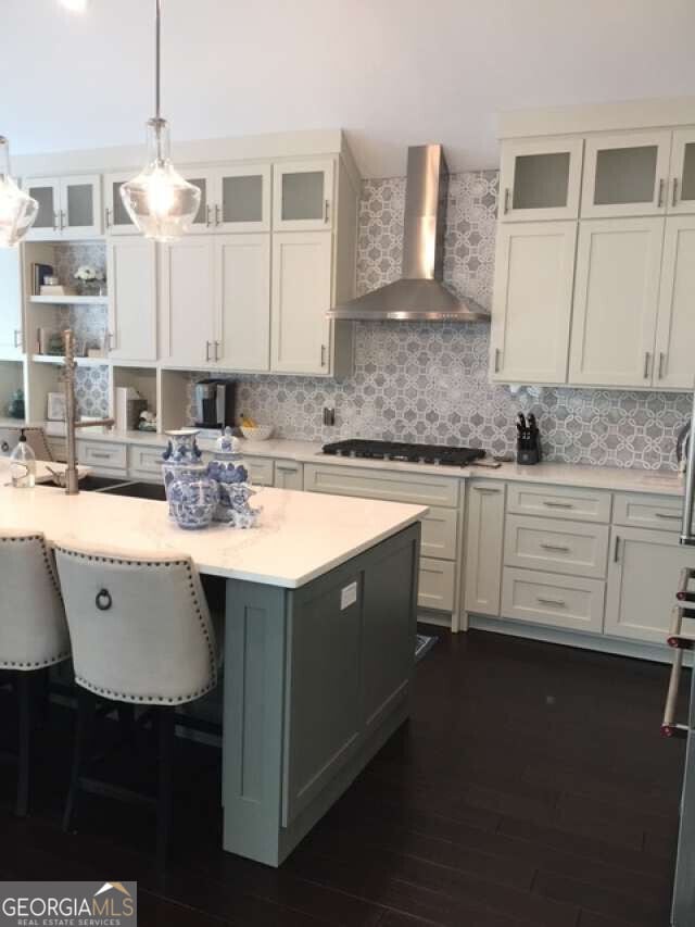 1305 Lake Forest Ln, Mcdonough, GA 30253 - kitchen featuring wall chimney exhaust hood, gas stovetop, light countertops, pendant lighting, and tasteful backsplash