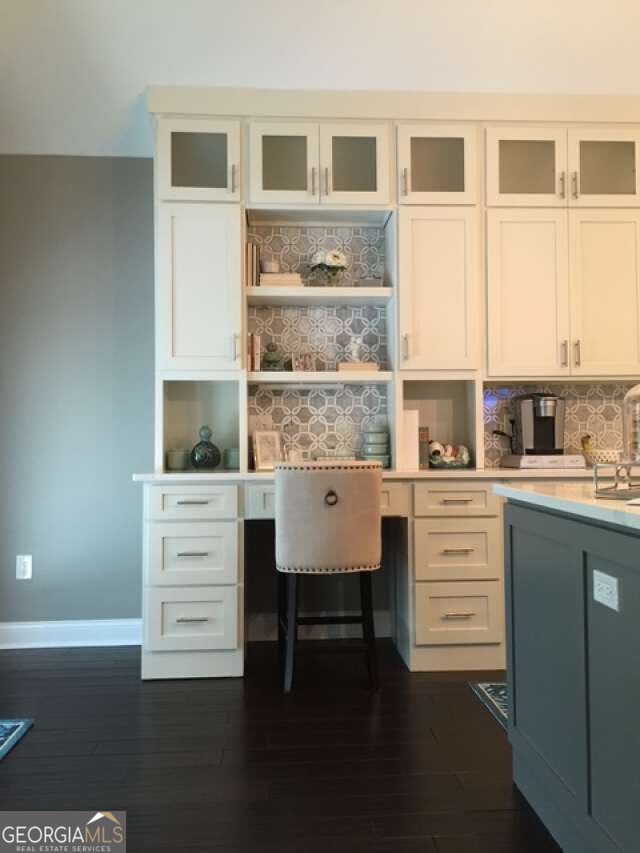 1305 Lake Forest Ln, Mcdonough, GA 30253 - home office with built in study area, baseboards, and dark wood-type flooring