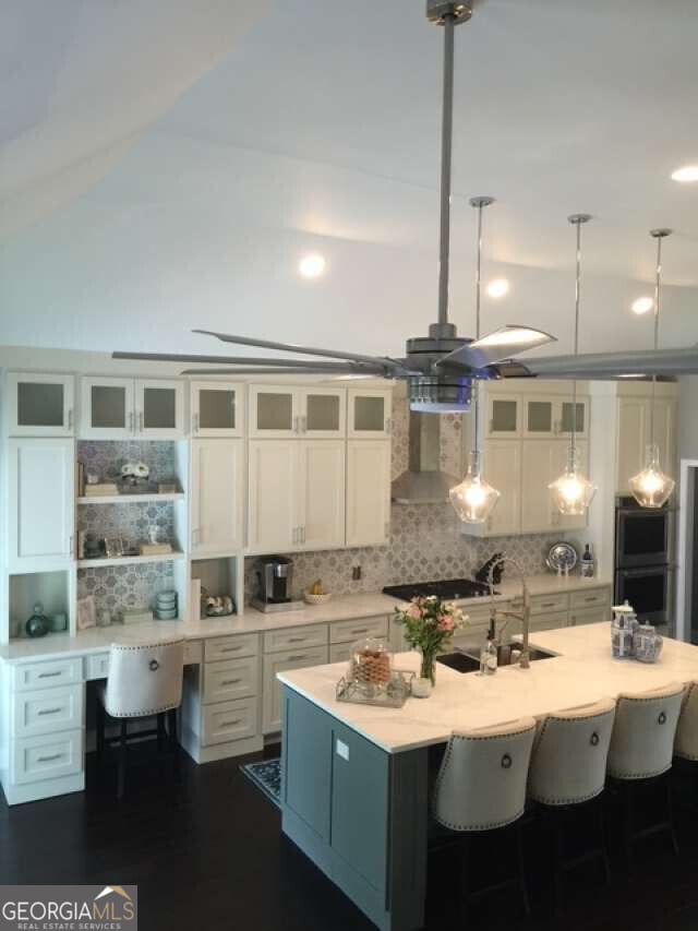 1305 Lake Forest Ln, Mcdonough, GA 30253 - kitchen with a sink, stainless steel double oven, decorative backsplash, white cabinets, and light countertops