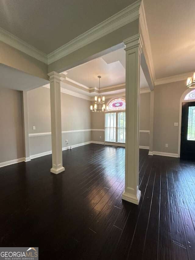 1305 Lake Forest Ln, Mcdonough, GA 30253 - foyer with a chandelier, dark wood-style floors, decorative columns, baseboards, and ornamental molding