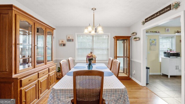 2675 Springside Ct, Douglasville, GA 30135 - dining room with a chandelier, light wood-style flooring, and a textured ceiling