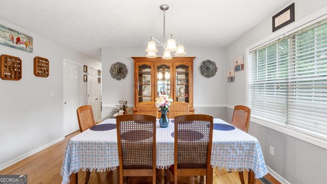 2675 Springside Ct, Douglasville, GA 30135 - dining space with a chandelier, baseboards, and light wood-style floors