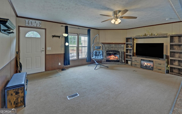 484 Tb Thornton Dr, Hartwell, GA 30643 - carpeted living room featuring a fireplace, a textured ceiling, crown molding, ceiling fan, and wainscoting
