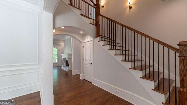 10765 Shallowford Rd, Roswell, GA 30075 - stairway featuring wood finished floors, arched walkways, a fireplace with raised hearth, and recessed lighting