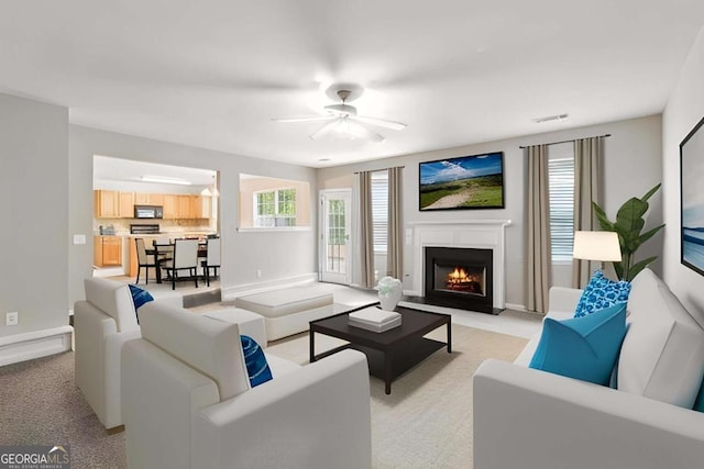 2896 Chilhowee Dr, Atlanta, GA 30331 - living area featuring light carpet, a lit fireplace, ceiling fan, and baseboards