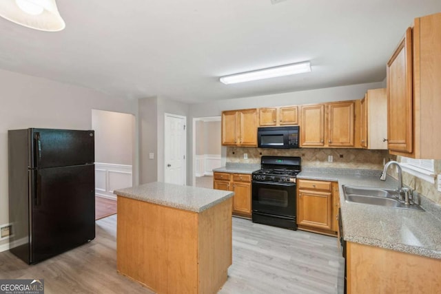 2896 Chilhowee Dr, Atlanta, GA 30331 - kitchen featuring black appliances, a sink, light wood-type flooring, a center island, and backsplash