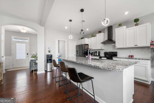 4607 Underwood Walk, Powder Springs, GA 30127 - kitchen with wall chimney range hood, black appliances, arched walkways, backsplash, and white cabinetry