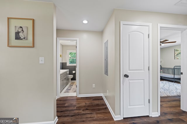 corridor featuring dark wood-style flooring, baseboards, and recessed lighting