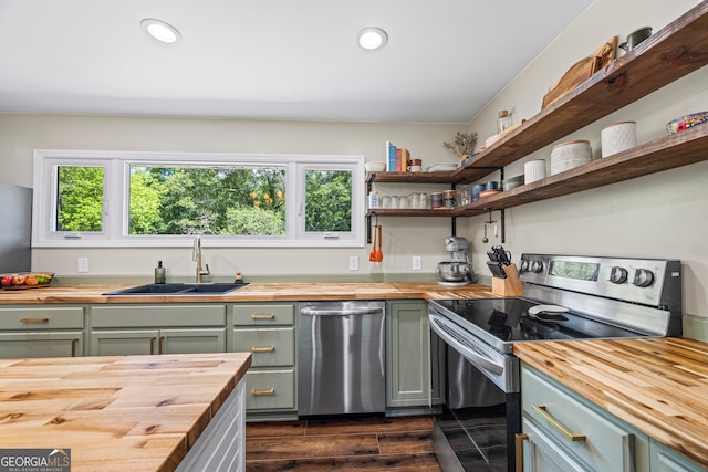 kitchen featuring butcher block counters, stainless steel appliances, a sink, plenty of natural light, and recessed lighting