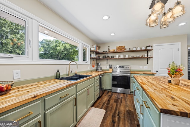 kitchen with butcher block countertops, green cabinetry, stainless steel appliances, a sink, and recessed lighting