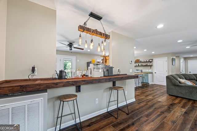 kitchen featuring butcher block countertops, dark wood finished floors, recessed lighting, a ceiling fan, and a kitchen bar