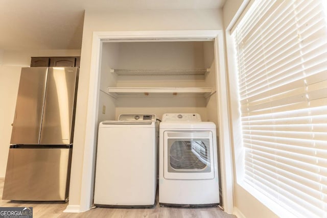 laundry area featuring washer and dryer and light wood finished floors