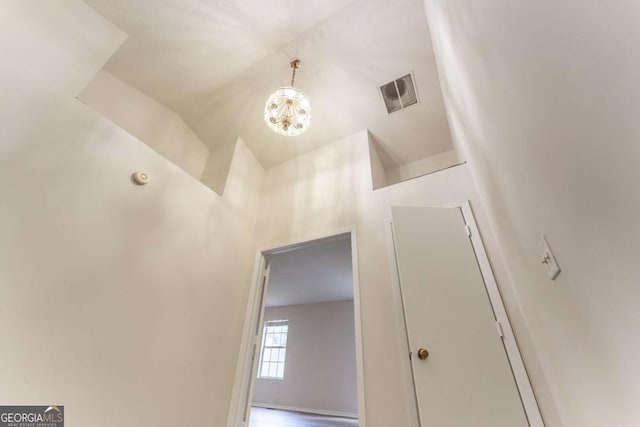 corridor featuring a chandelier and a high ceiling