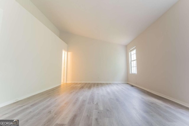unfurnished room with light wood-type flooring and baseboards