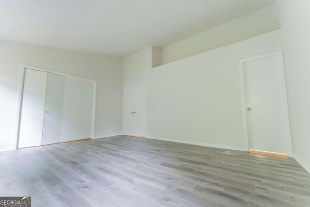 unfurnished bedroom with light wood finished floors, a closet, and baseboards