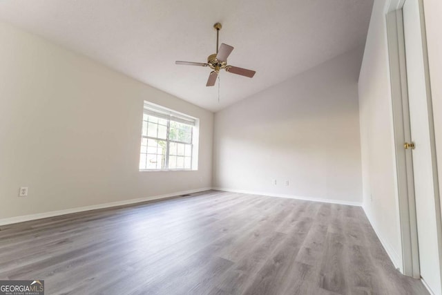 spare room with lofted ceiling, wood finished floors, ceiling fan, and baseboards