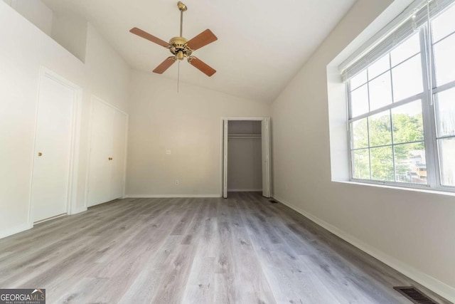 unfurnished bedroom with lofted ceiling, light wood-style flooring, baseboards, and ceiling fan