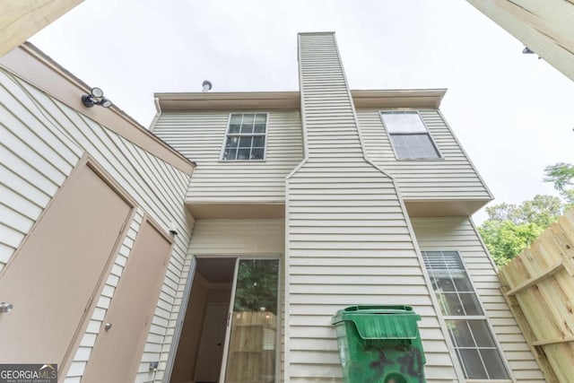 rear view of property featuring fence and a chimney