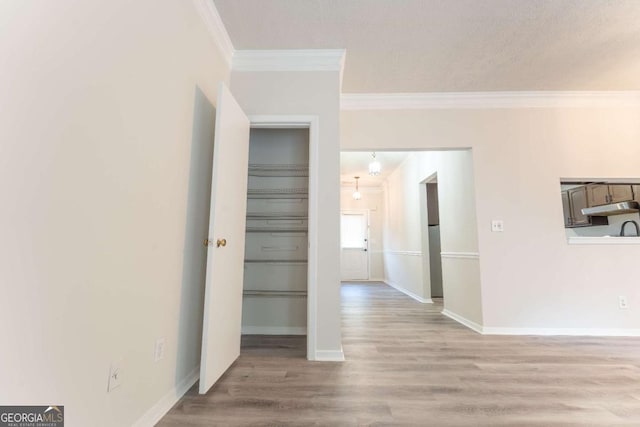 empty room featuring ornamental molding, wood finished floors, and baseboards