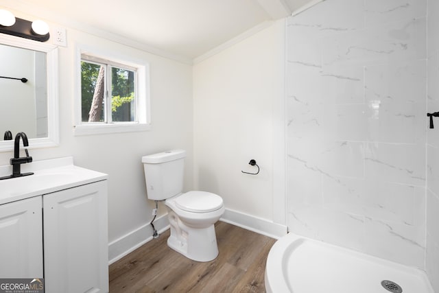 bathroom with toilet, vanity, wood finished floors, a shower stall, and baseboards